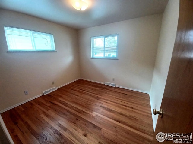 spare room featuring wood-type flooring