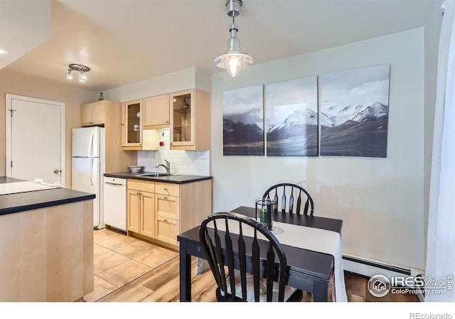 kitchen with white appliances, a baseboard heating unit, sink, decorative light fixtures, and backsplash