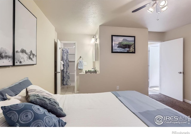 carpeted bedroom featuring ensuite bath, a textured ceiling, ceiling fan, and a closet