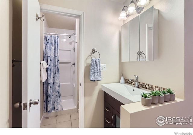 bathroom with a shower with curtain, vanity, tile patterned floors, and decorative backsplash