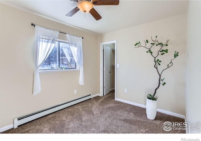 carpeted empty room with ceiling fan and a baseboard heating unit