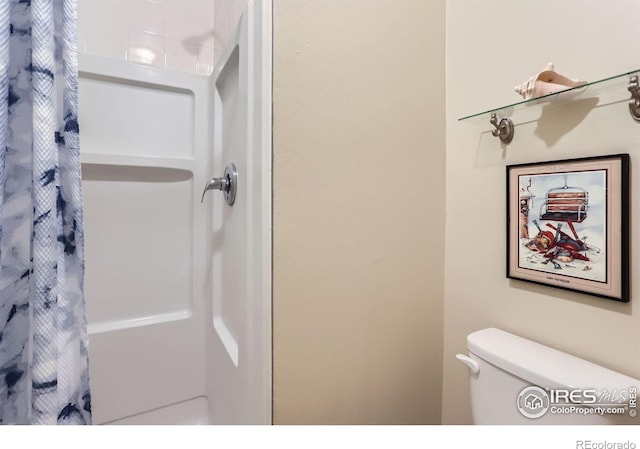 bathroom with curtained shower and toilet