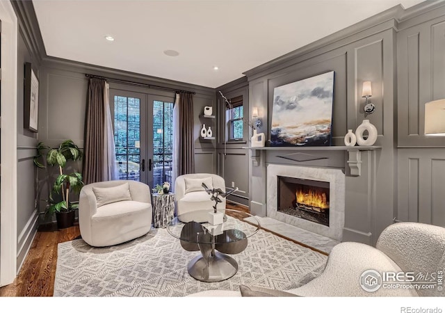 sitting room with ornamental molding, dark wood-type flooring, french doors, and a fireplace