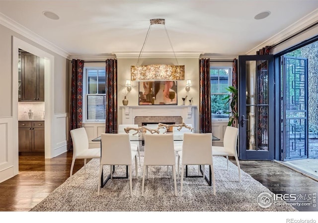 dining space featuring dark wood-type flooring and crown molding