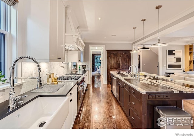 kitchen with sink, stainless steel appliances, dark brown cabinets, and hanging light fixtures