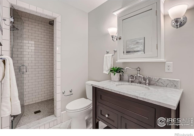 bathroom with vanity, a shower with shower door, and toilet