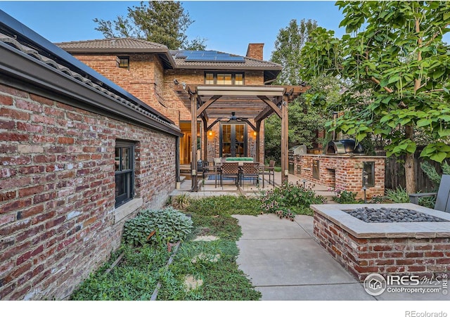 view of patio featuring french doors, an outdoor fire pit, and exterior kitchen