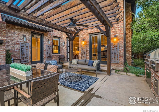 view of patio featuring a pergola, an outdoor hangout area, and an outdoor kitchen