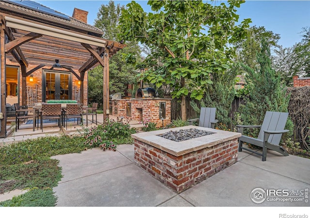 view of patio with an outdoor living space with a fire pit, ceiling fan, and area for grilling