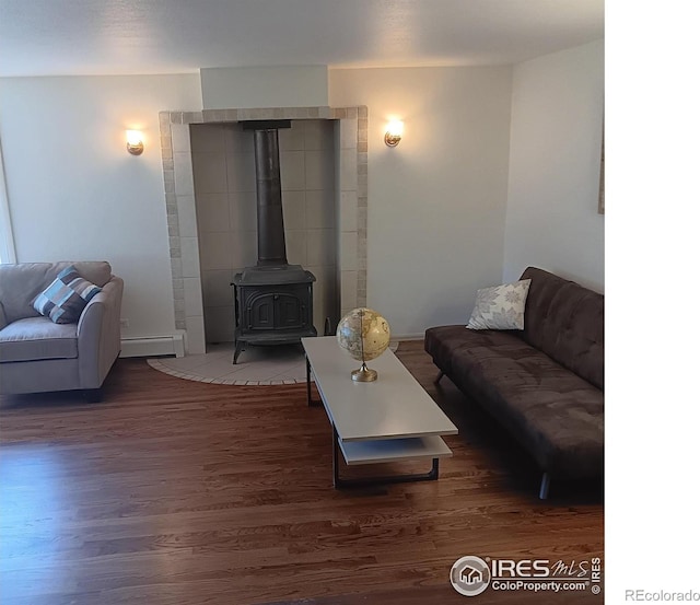 living room featuring a baseboard radiator, a wood stove, and dark hardwood / wood-style flooring