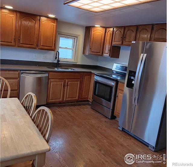 kitchen with stainless steel appliances, dark hardwood / wood-style flooring, and sink