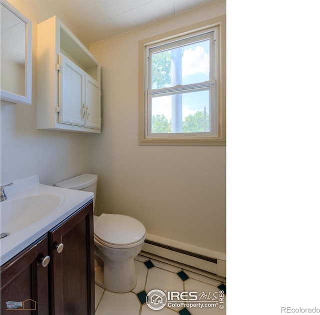 bathroom featuring vanity, a baseboard heating unit, and toilet