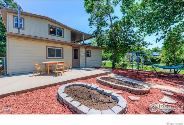 rear view of house with a patio and an outdoor fire pit