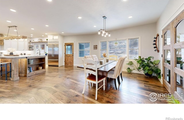 dining space featuring sink and an inviting chandelier