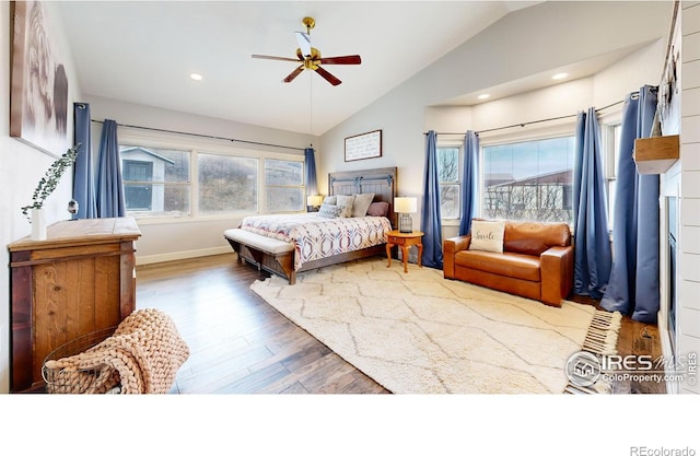 bedroom featuring vaulted ceiling, ceiling fan, wood-type flooring, and multiple windows