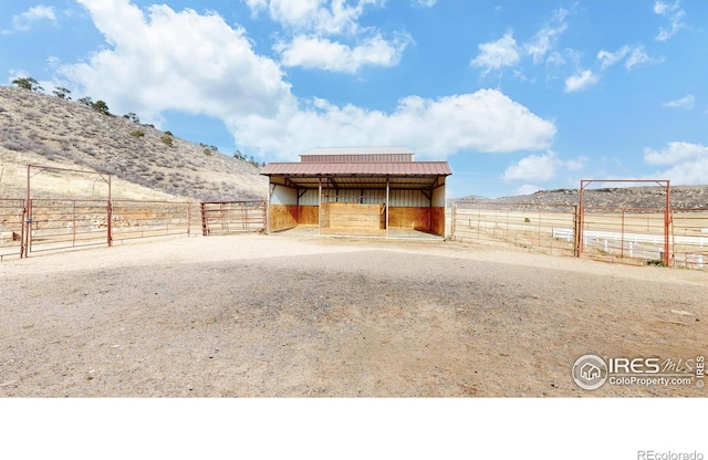 view of outbuilding featuring a rural view and a mountain view