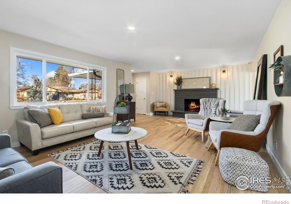 living room with hardwood / wood-style floors and a brick fireplace