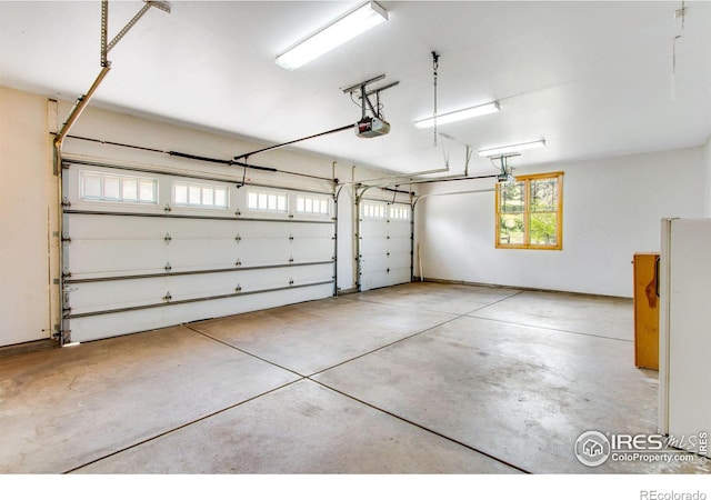 garage with white refrigerator and a garage door opener