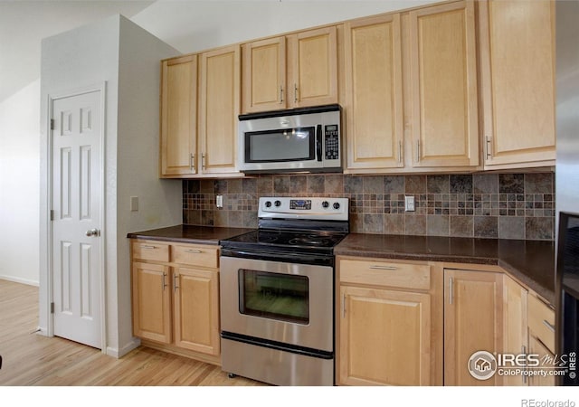 kitchen with tasteful backsplash, light brown cabinets, stainless steel appliances, and light wood-type flooring