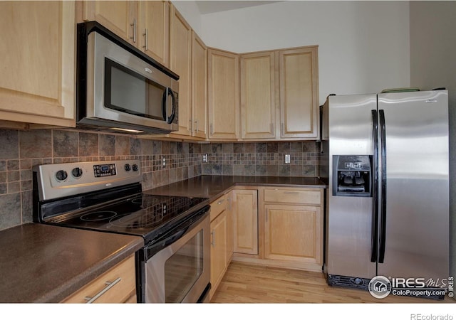 kitchen featuring decorative backsplash, light brown cabinets, and stainless steel appliances