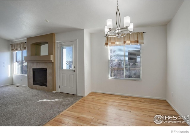 interior space featuring hardwood / wood-style floors, a chandelier, and a fireplace