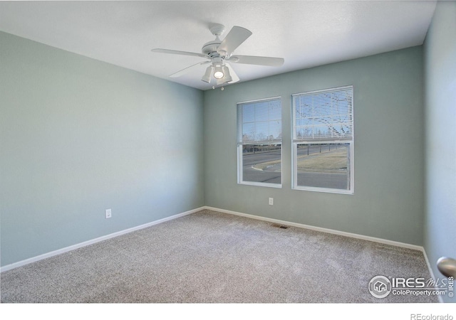 carpeted spare room featuring ceiling fan