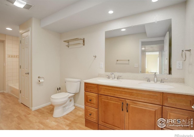 full bathroom with toilet, vanity, hardwood / wood-style floors, and tiled shower / bath