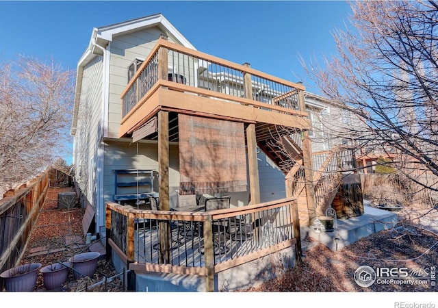 back of house featuring a balcony and a deck