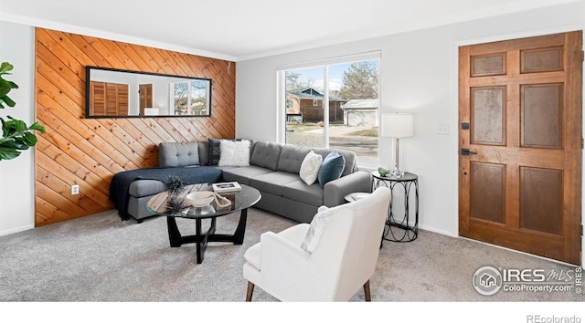 carpeted living room featuring wood walls and crown molding