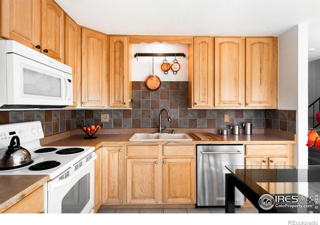 kitchen with white appliances, light brown cabinetry, backsplash, and sink