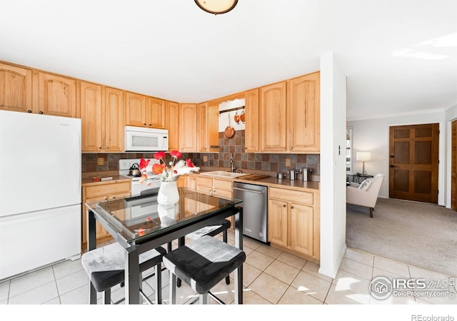 kitchen featuring sink, white appliances, light tile patterned flooring, and light brown cabinetry