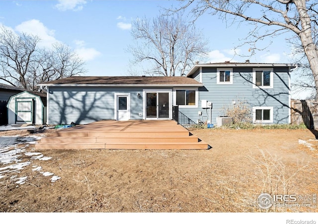 rear view of property featuring central air condition unit, a deck, and a shed