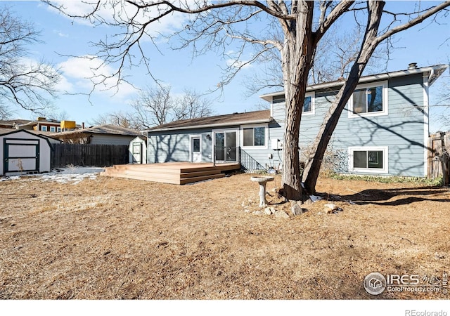 rear view of property featuring a wooden deck and a shed