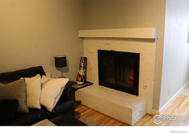 interior space featuring a brick fireplace and hardwood / wood-style flooring