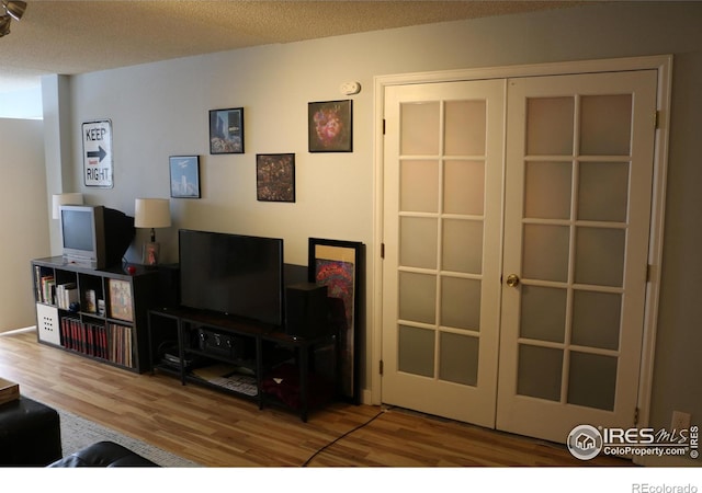 misc room with a textured ceiling and hardwood / wood-style floors