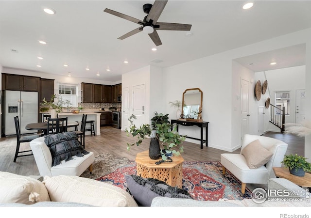 living room with ceiling fan and light hardwood / wood-style floors