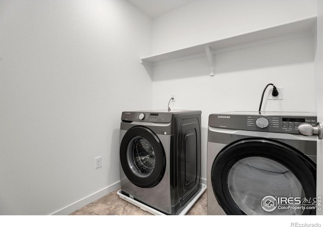 clothes washing area featuring light tile patterned flooring and washing machine and clothes dryer