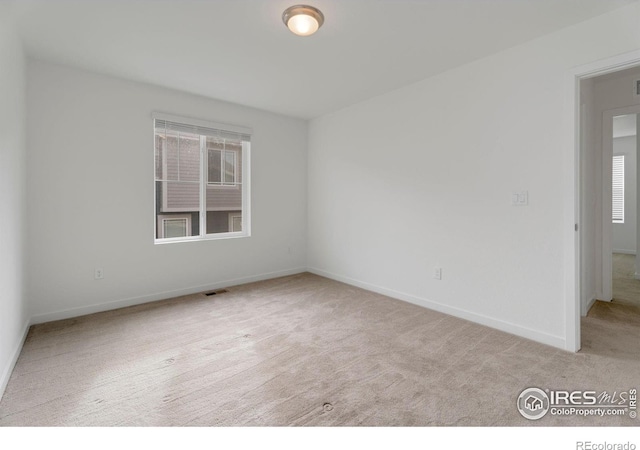 unfurnished room featuring light carpet