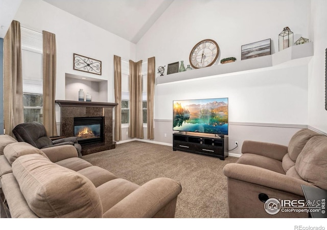 living room with a premium fireplace, high vaulted ceiling, and carpet flooring