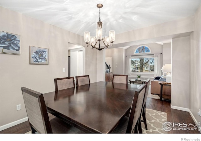 dining area with a notable chandelier and dark hardwood / wood-style floors