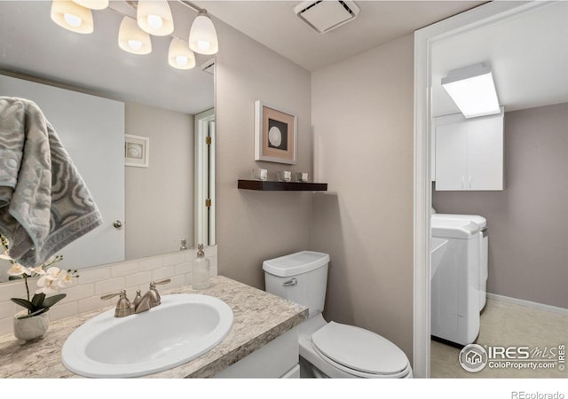 bathroom with decorative backsplash, washing machine and dryer, vanity, and toilet