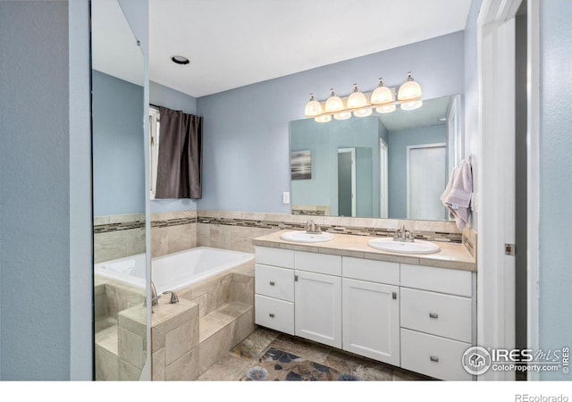 bathroom featuring vanity and tiled bath