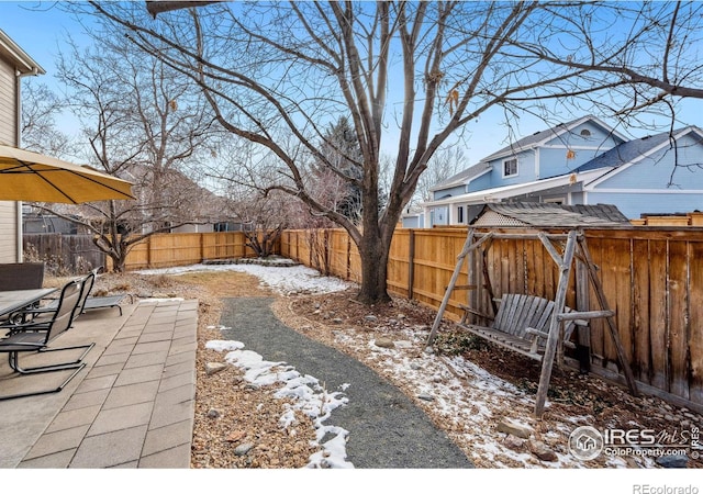 yard layered in snow featuring a patio