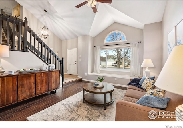 living room featuring ceiling fan with notable chandelier, vaulted ceiling, and dark hardwood / wood-style floors