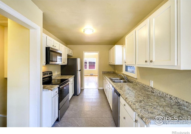 kitchen with appliances with stainless steel finishes, white cabinets, and sink