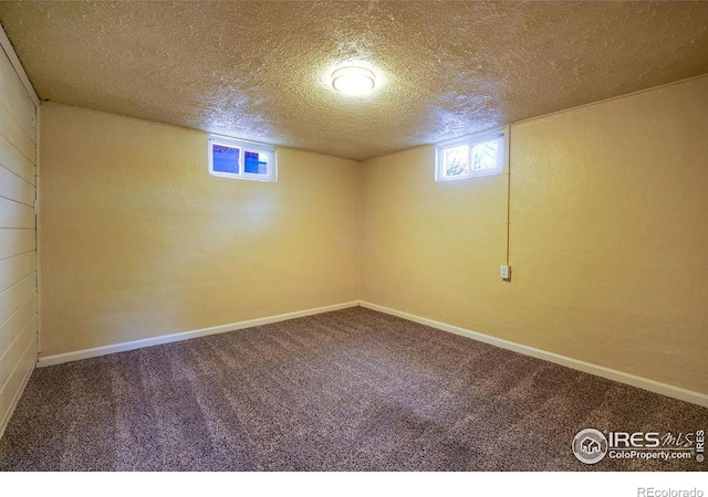 basement featuring a textured ceiling and carpet flooring