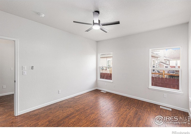 spare room featuring a textured ceiling, baseboards, a ceiling fan, and wood finished floors