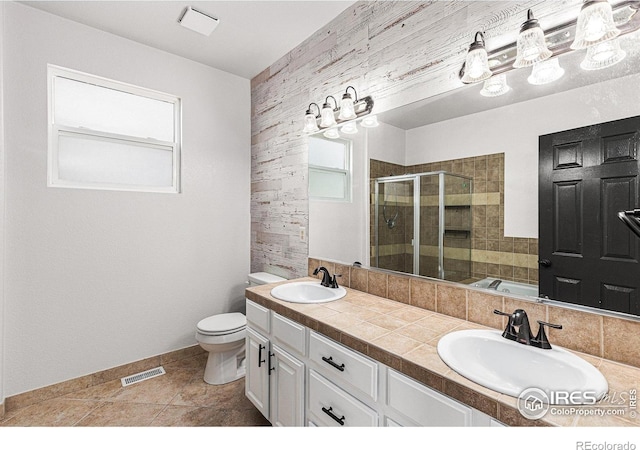 full bathroom featuring a stall shower, a healthy amount of sunlight, visible vents, and a sink