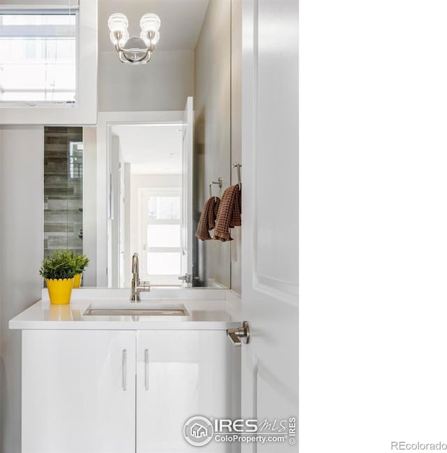 bathroom with plenty of natural light, vanity, and an inviting chandelier