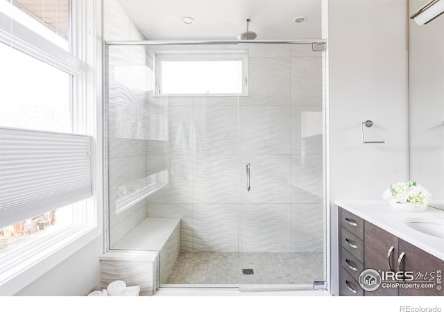 bathroom with a shower with door and vanity